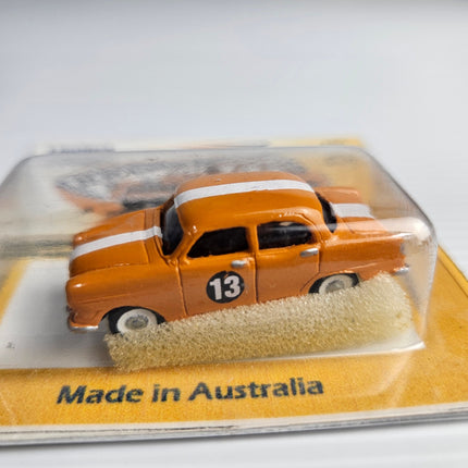 Side close-up of orange Weico FE Holden Race Car No. 13 with white racing stripe
